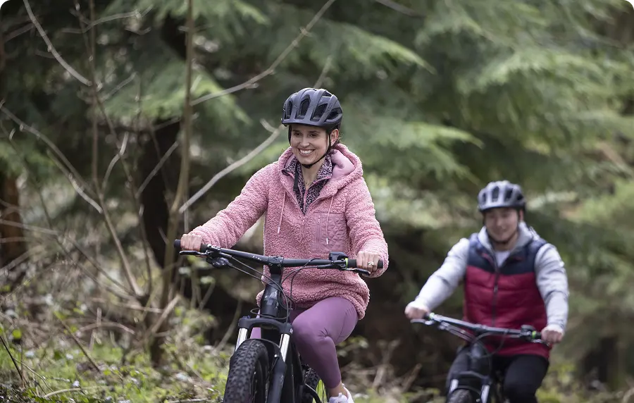 A couple cycling in forest trail